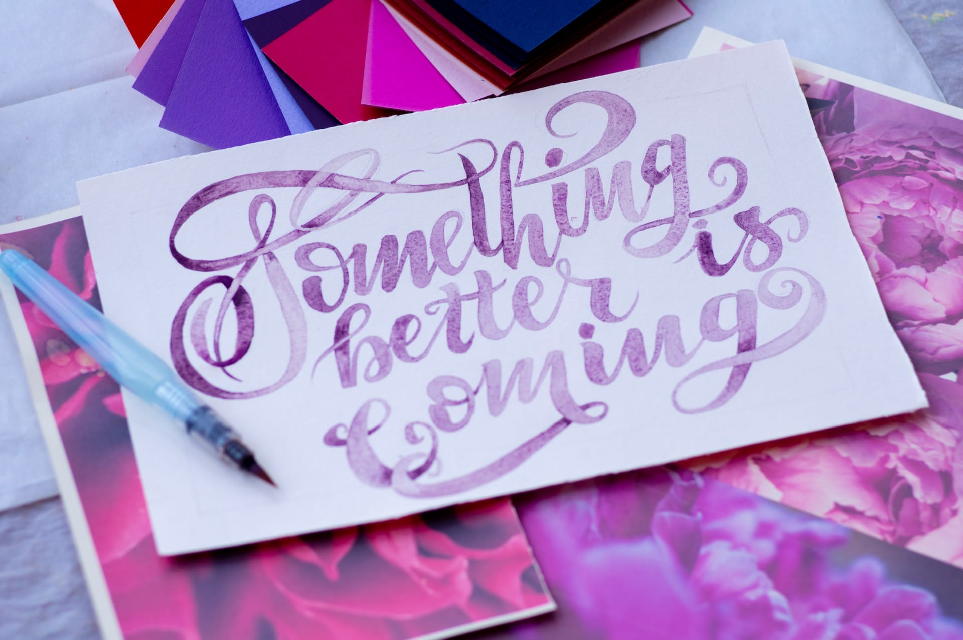 A watercolor calligraphy artwork featuring the positive affirmation 'Something better is coming'. The elegant, flowing script and the use of vibrant colors emphasize the uplifting and hopeful message, ideal for inspiring optimism and a positive outlook.