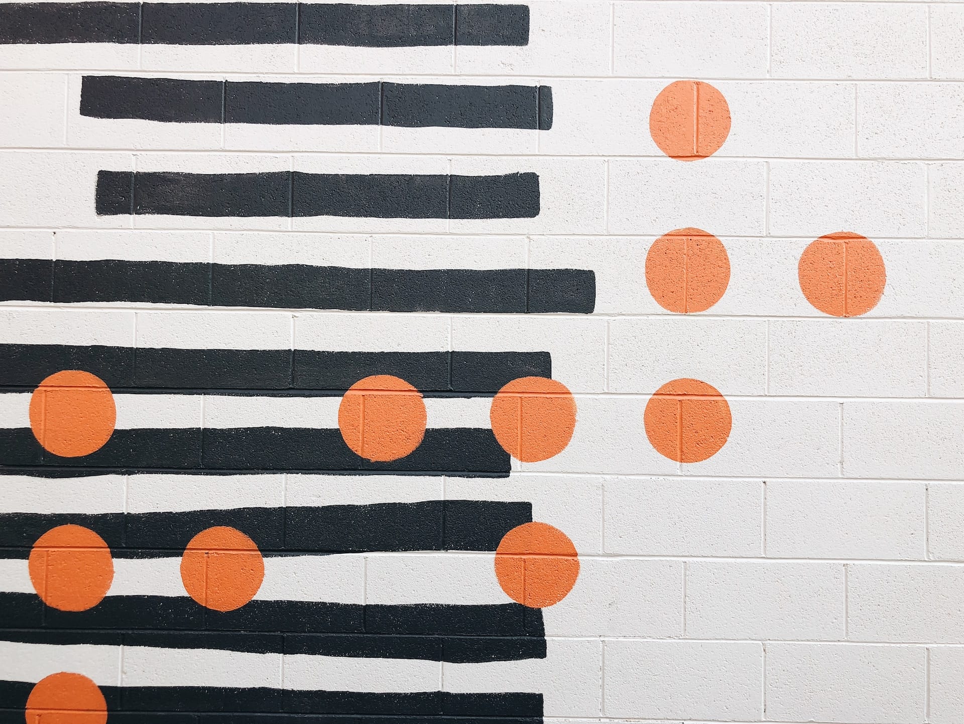 A mural composed of black rectangles and vibrant, orange circles. The abstract design symbolizes the concept of connecting the dots in free association, where each shape represents an idea or thought leading to deeper subconscious insights.